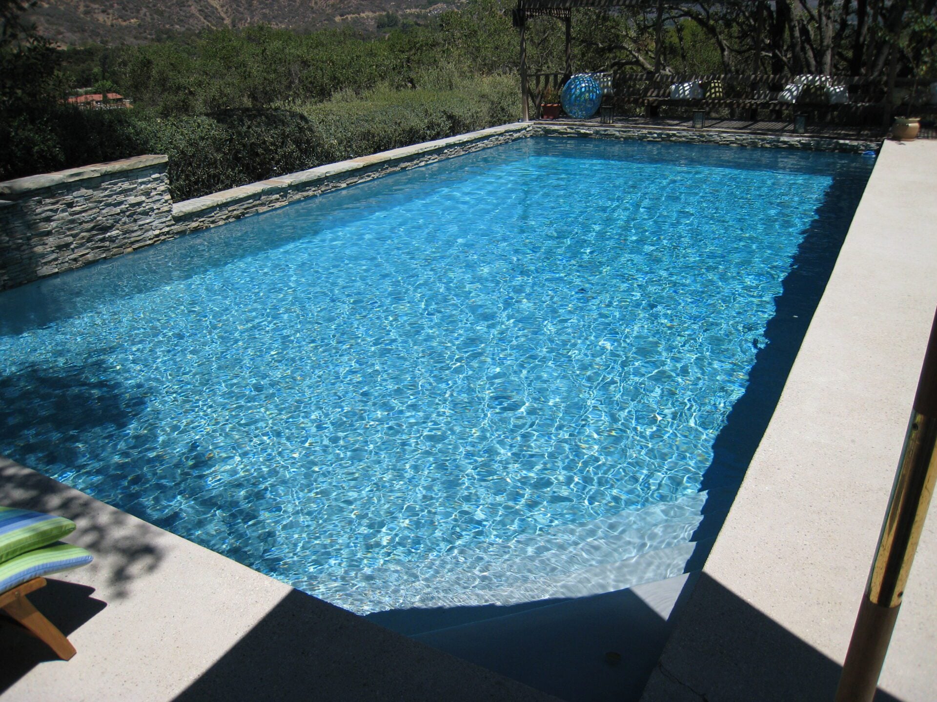 Pool beside a stacked stone wall