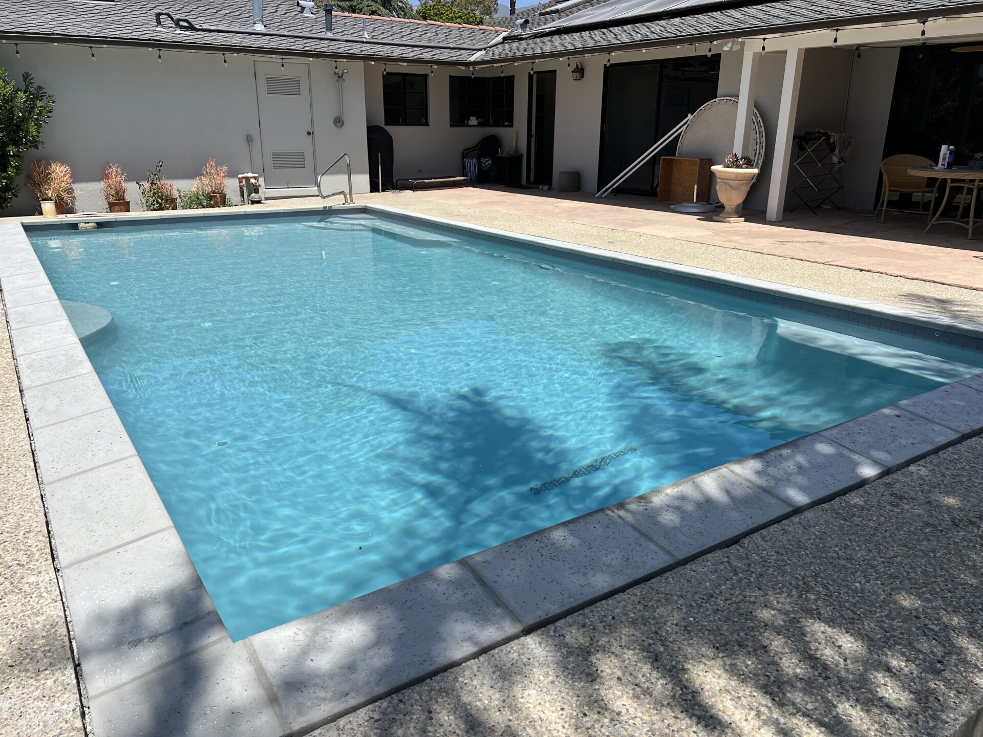 Backyard pool with new coping, waterline tile, and an Iridium AQUA-GLASS finish