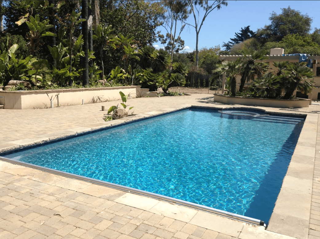 Rectangular backyard pool set in a garden resurfaced by Aqua Creations